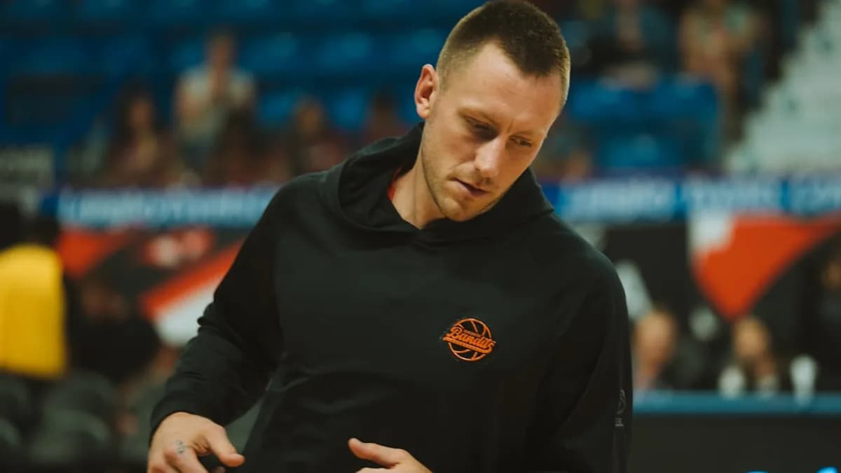 A basketball player wears a black hoodie.