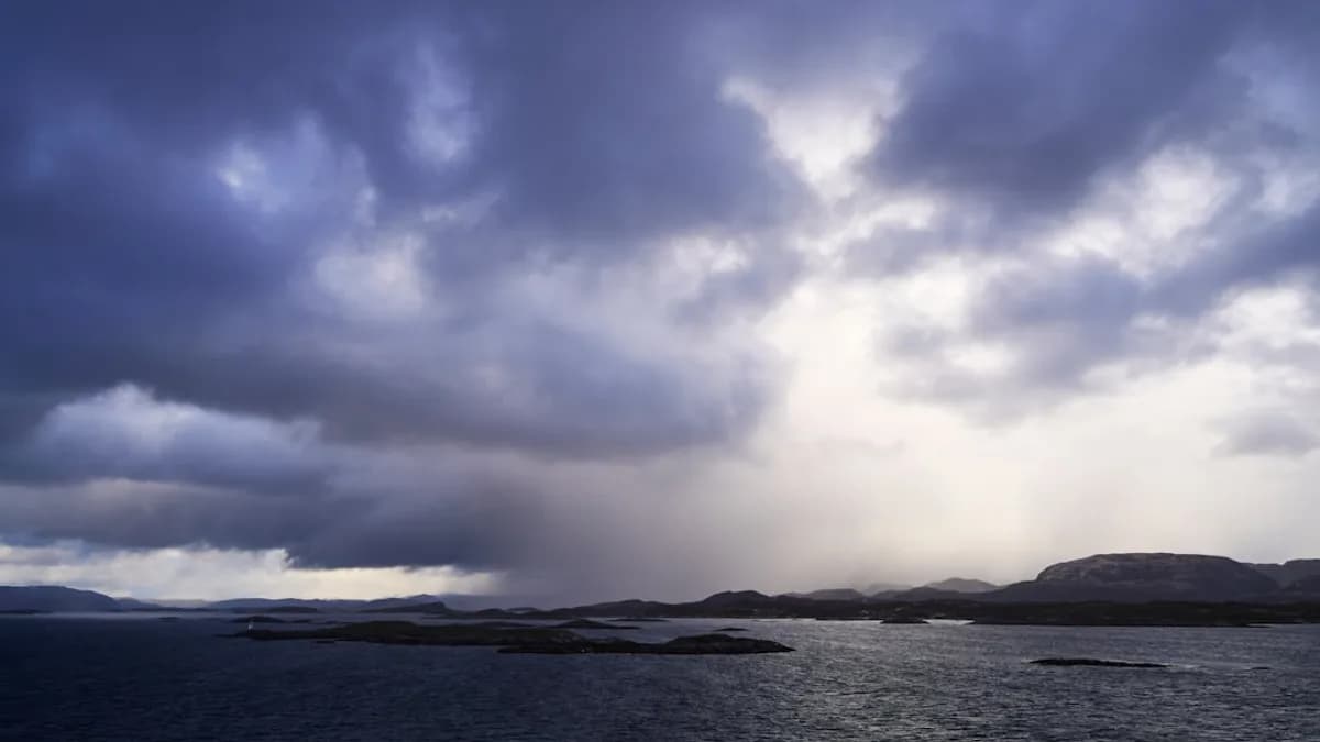 Dark storm clouds gather over a choppy sea.