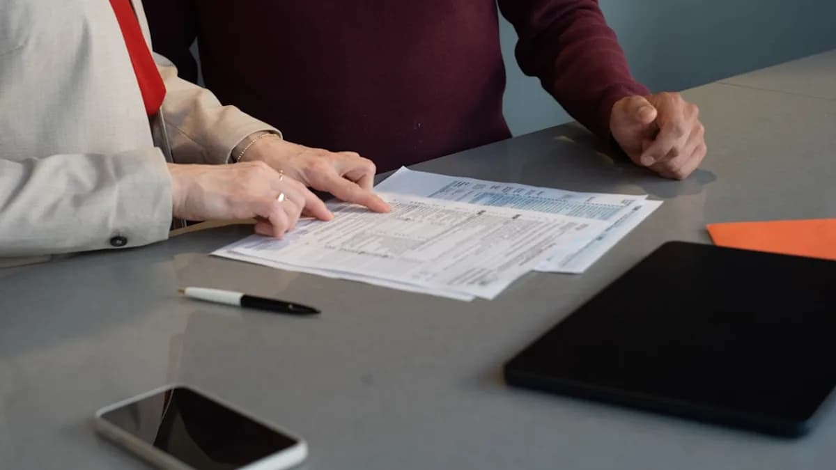 Two people reviewing documents at a table.