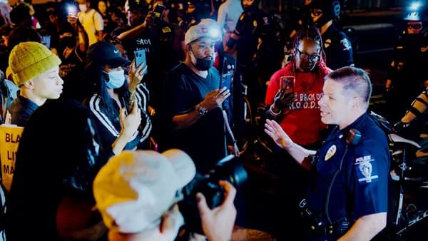 man in blue and white costume standing beside man in red and white jersey shirt