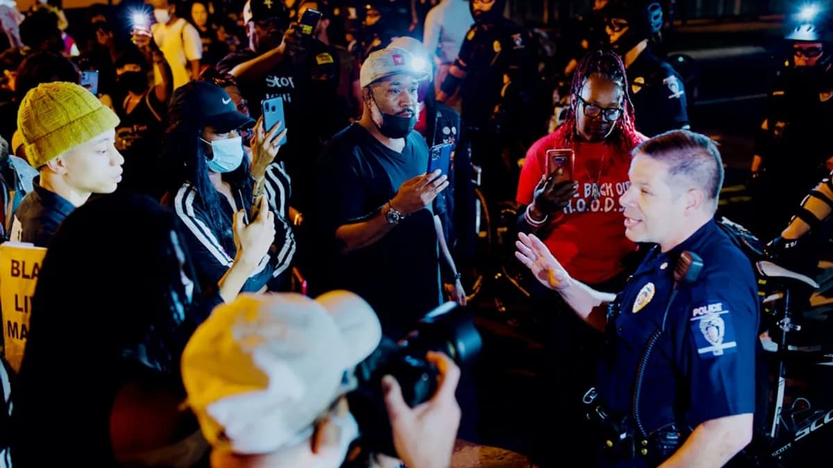 man in blue and white costume standing beside man in red and white jersey shirt