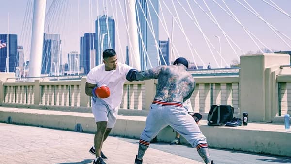 man in white shirt and white pants playing ice hockey during daytime