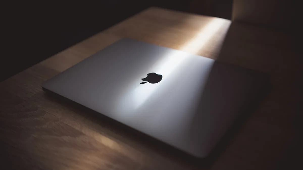 silver macbook on brown wooden table
