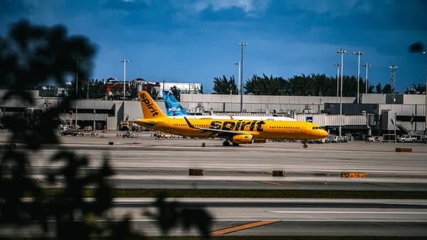 A yellow and blue plane is on the runway