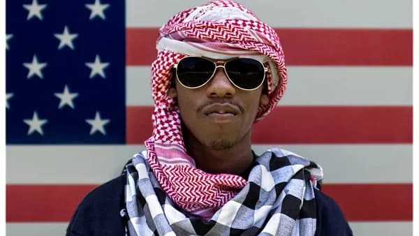 man wearing sunglasses in front of American flag