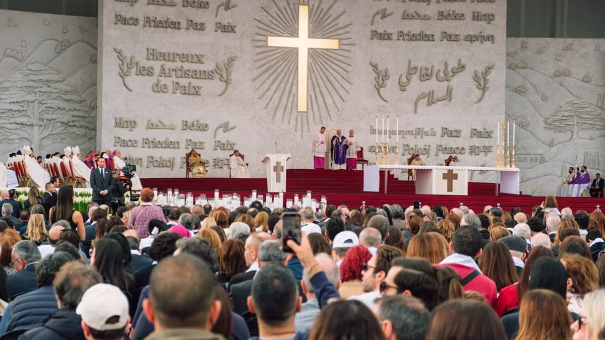 Religious ceremony with a large crowd and cross
