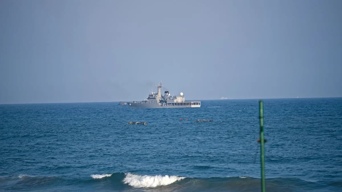 A modern warship sails on the blue ocean.