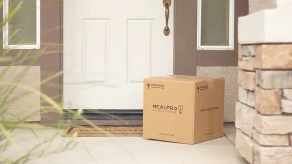brown cardboard box beside white wooden door