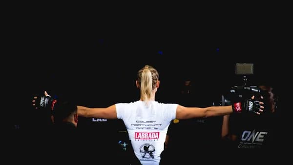 woman wearing white shirt and black grappling gloves