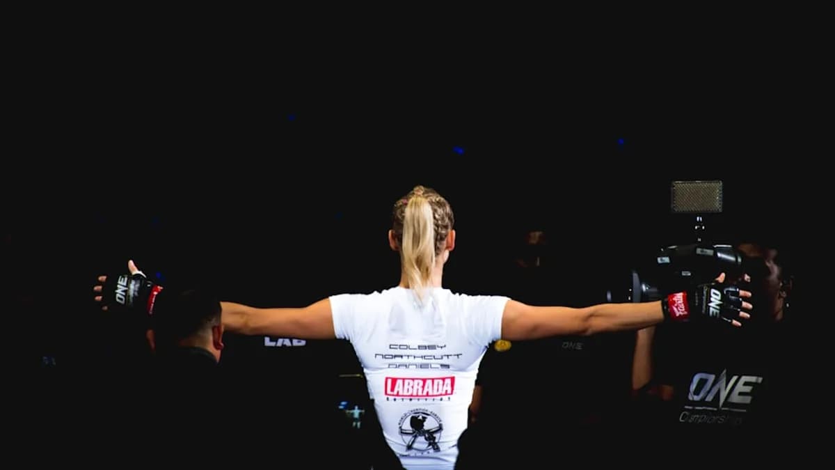woman wearing white shirt and black grappling gloves