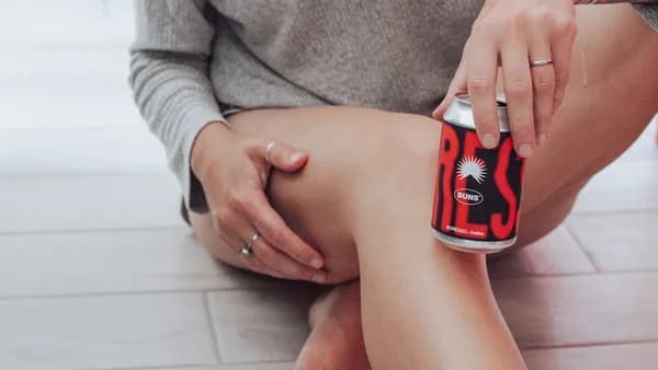 a woman sitting on the floor holding a can of soda