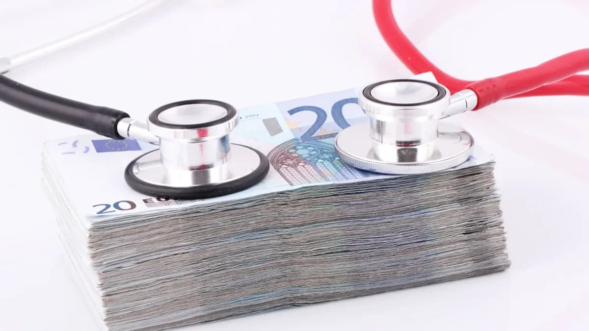 a pile of money with a stethoscope on top of it