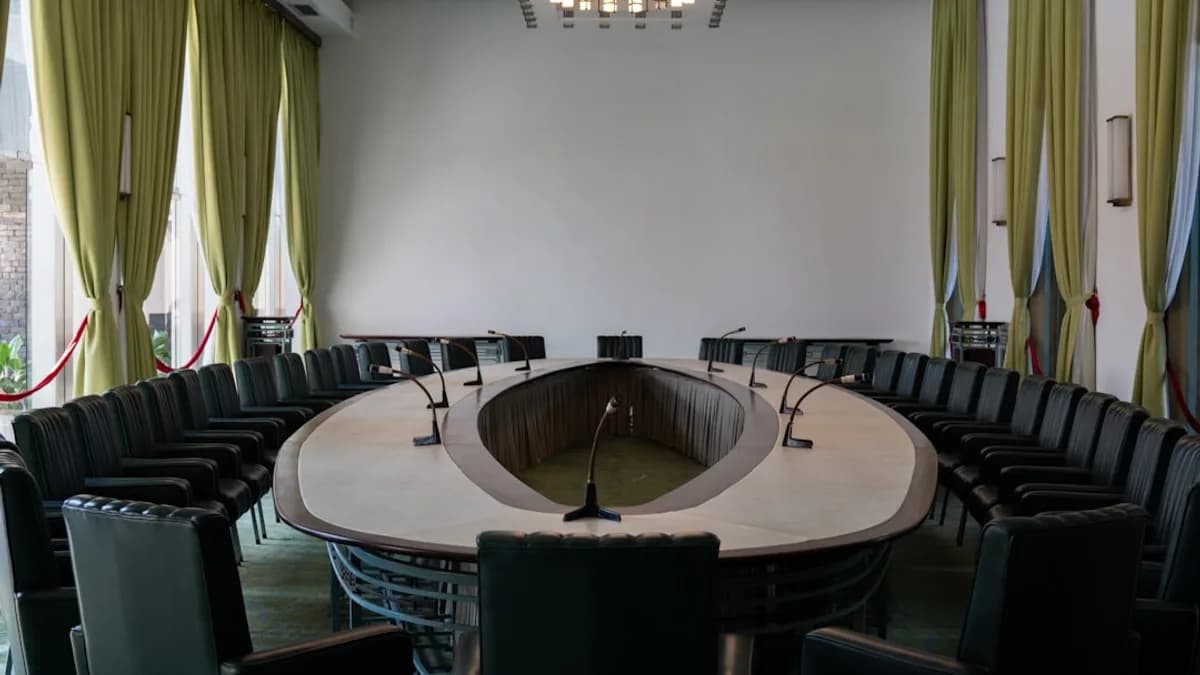 A conference room with a round table and black chairs