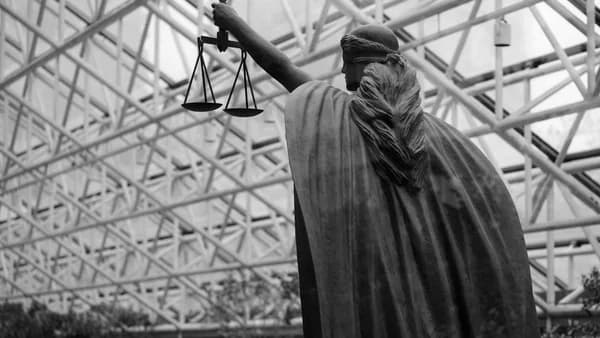 Statue of lady justice holding scales indoors