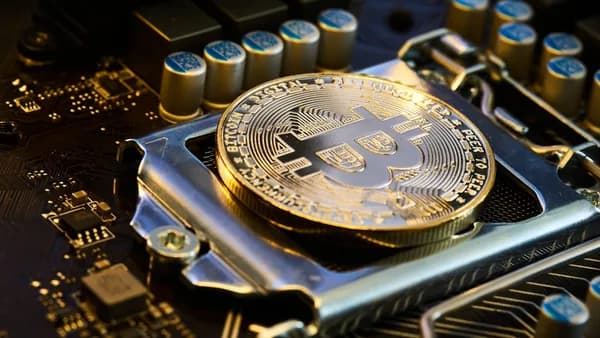 a bit coin sitting on top of a motherboard