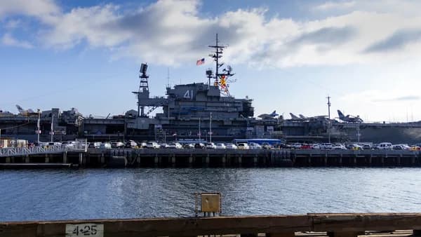 A large ship docked in a harbor next to a pier