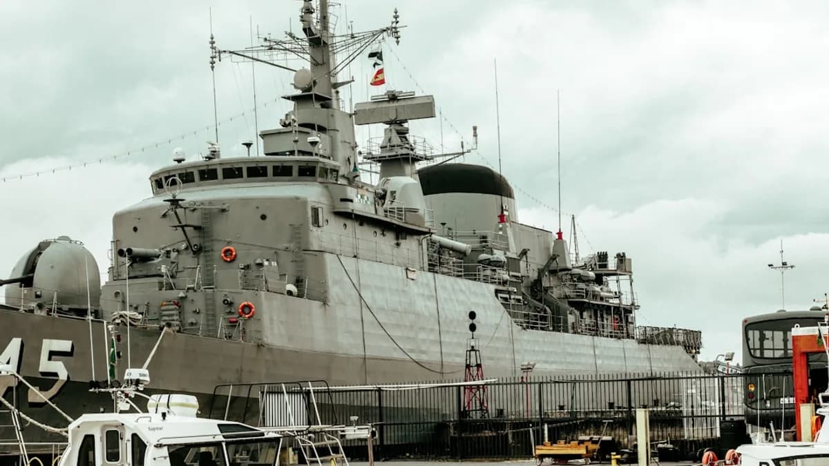 a large gray ship docked at a dock