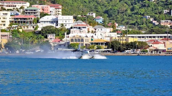 a small plane flying over a body of water