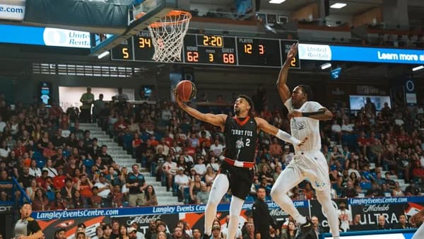 Basketball player shoots the ball over an opponent.