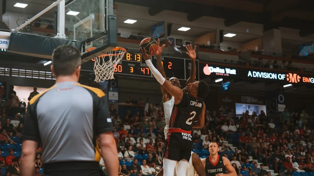 A basketball player attempts a shot.