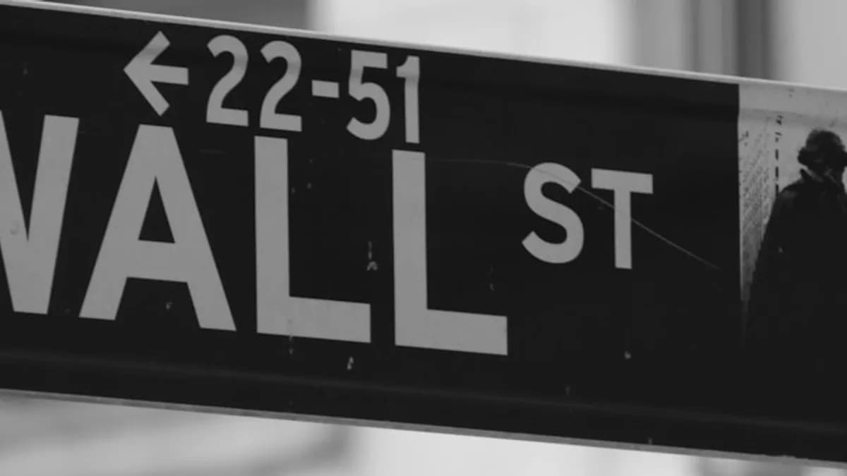 a black and white photo of a wall street sign