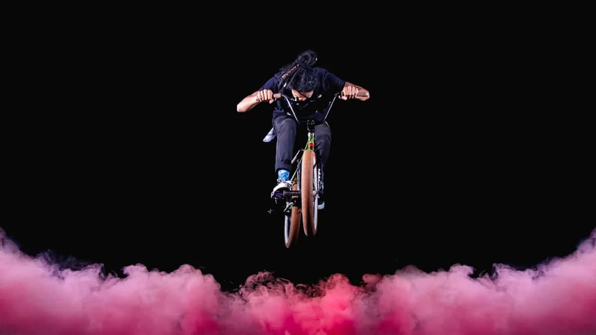 man riding BMX bike performing stunts with red fogs