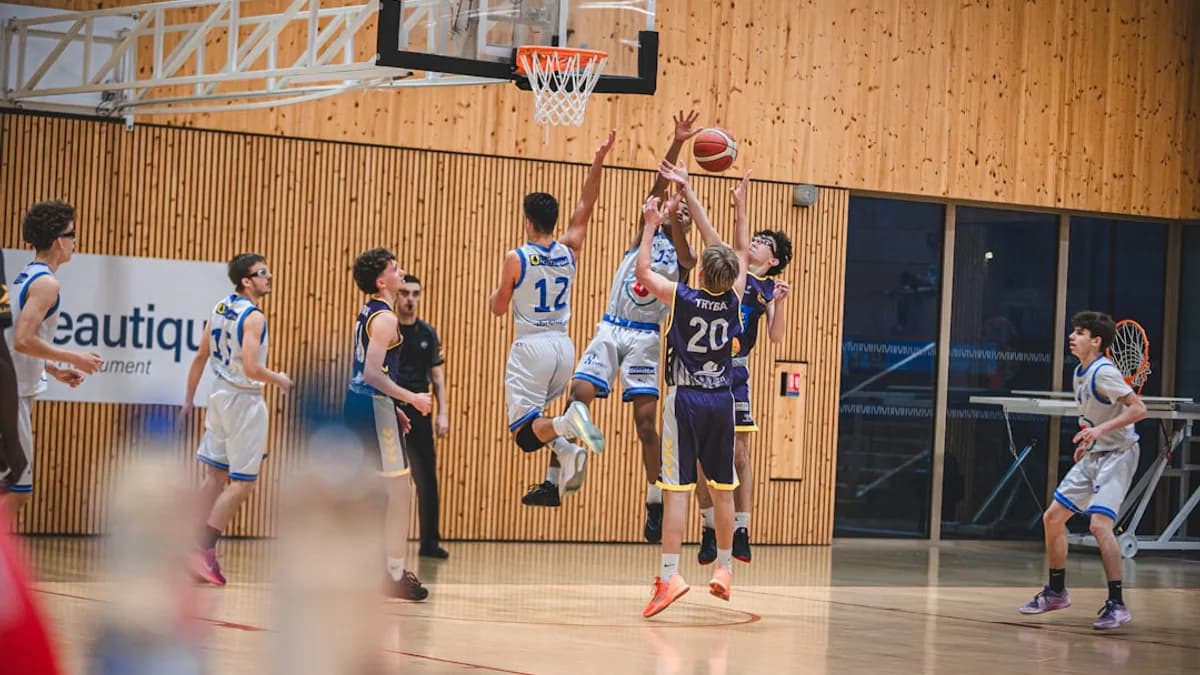 Basketball players jump for the ball during a game.