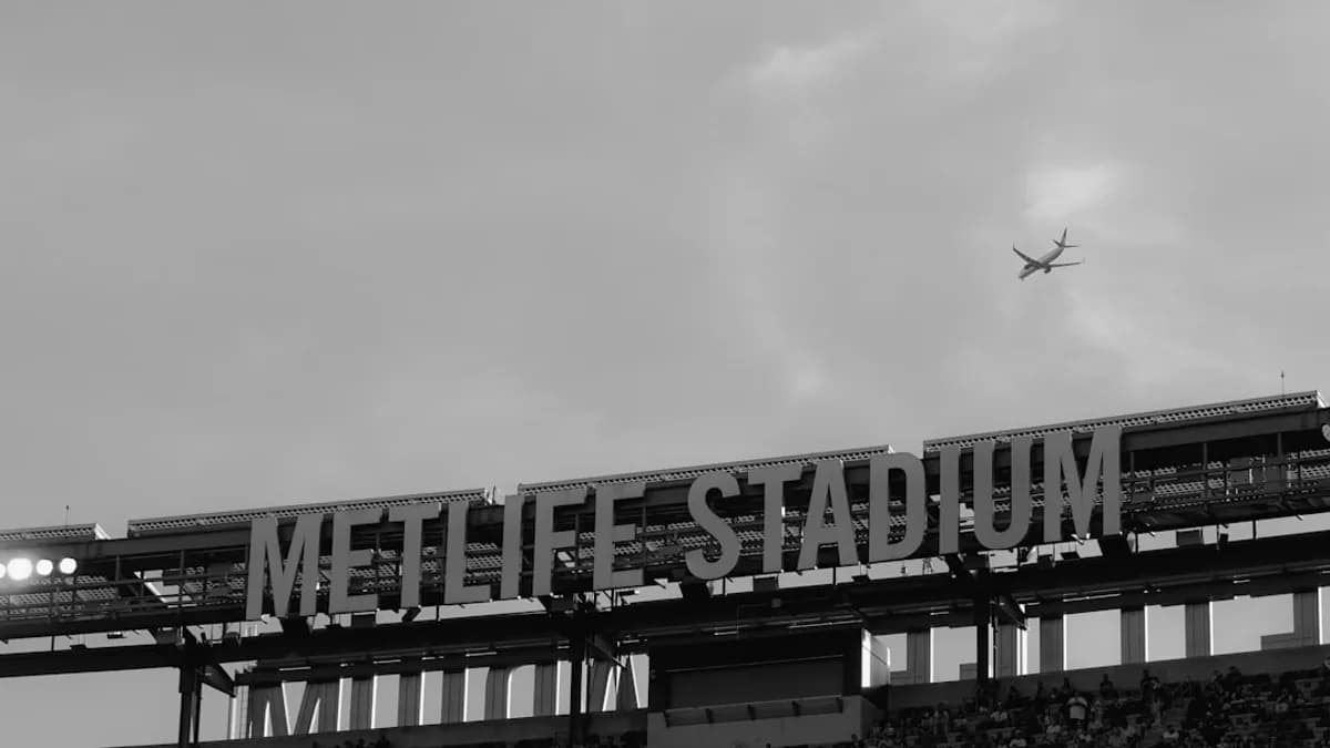 an airplane is flying over a stadium with a sign