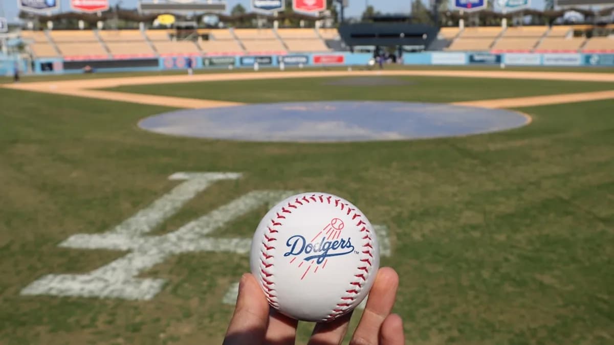 a person holding a baseball in front of a baseball field