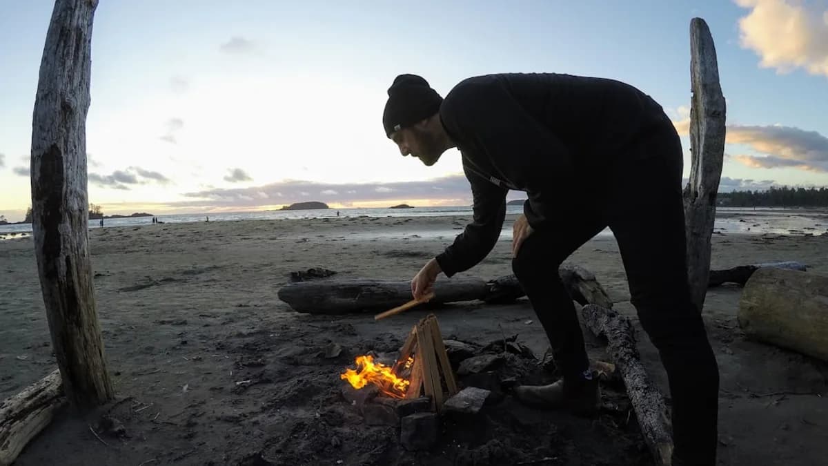 man in black long sleeve shirt and black pants holding fire