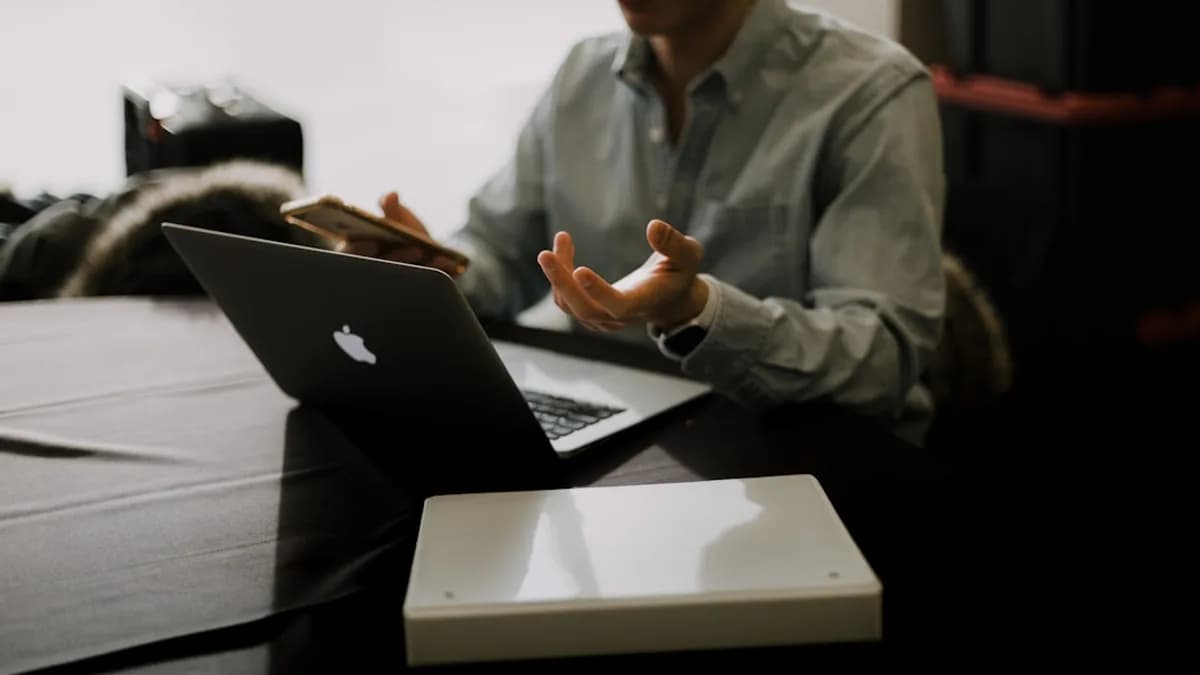 a man sitting at a table with a laptop in front of him