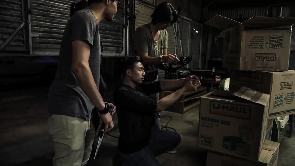 two man standing in front of man sitting in front of box inside building