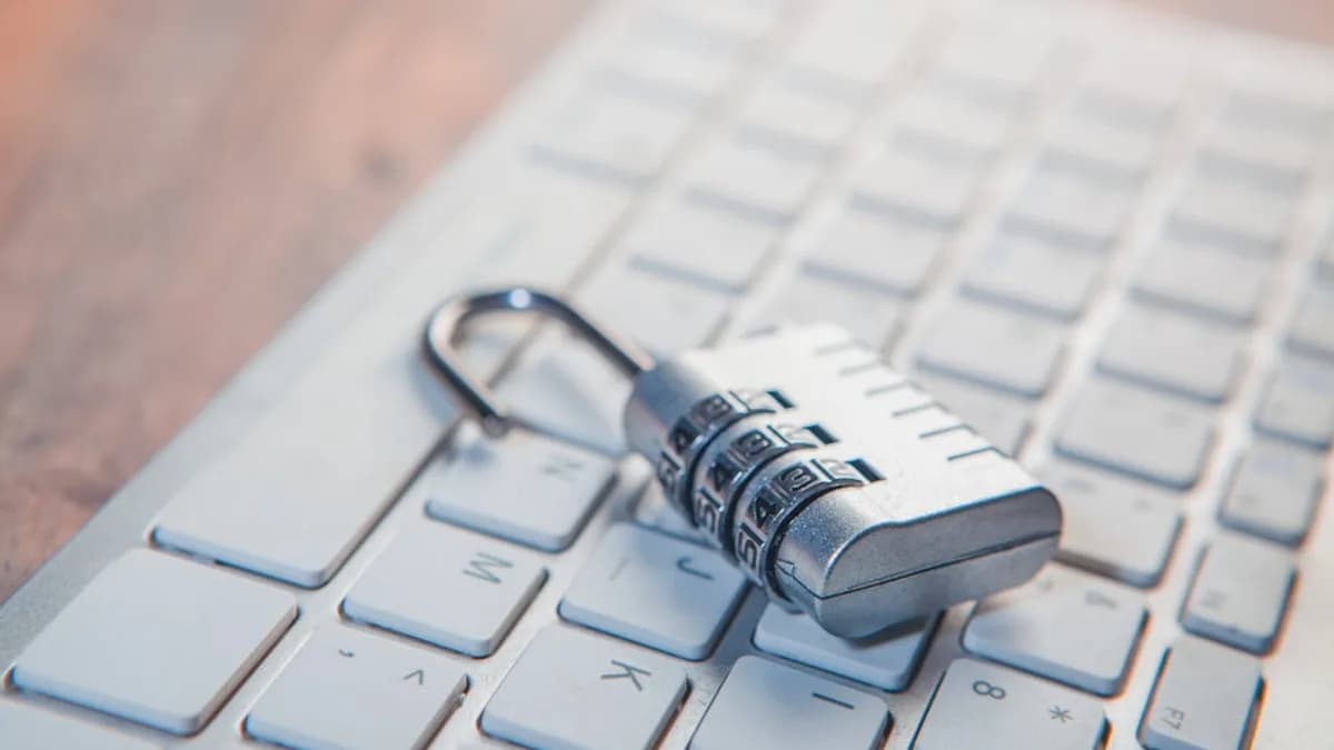 A combination lock rests on a computer keyboard.