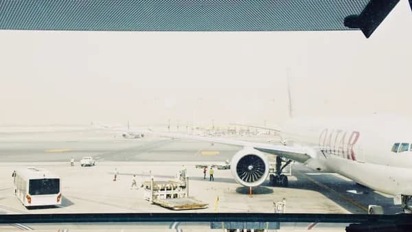 white Qatar airplane on airport during daytime