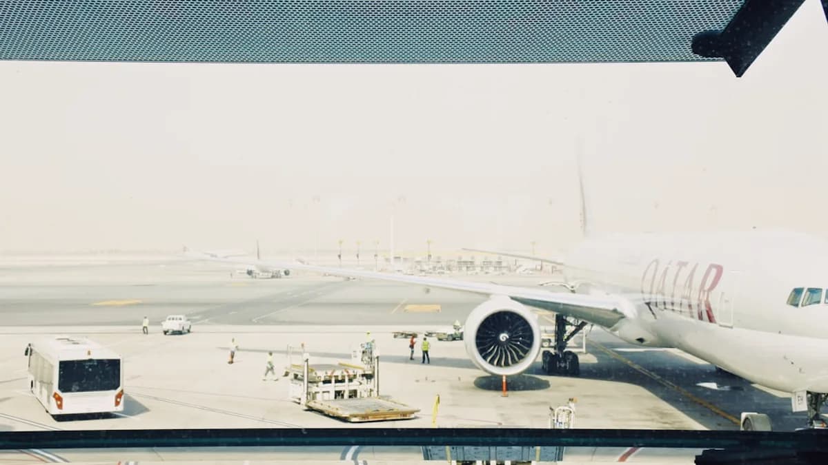 white Qatar airplane on airport during daytime