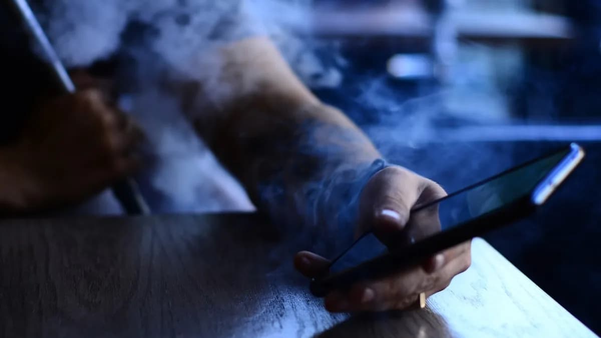 a person sitting at a table using a cell phone