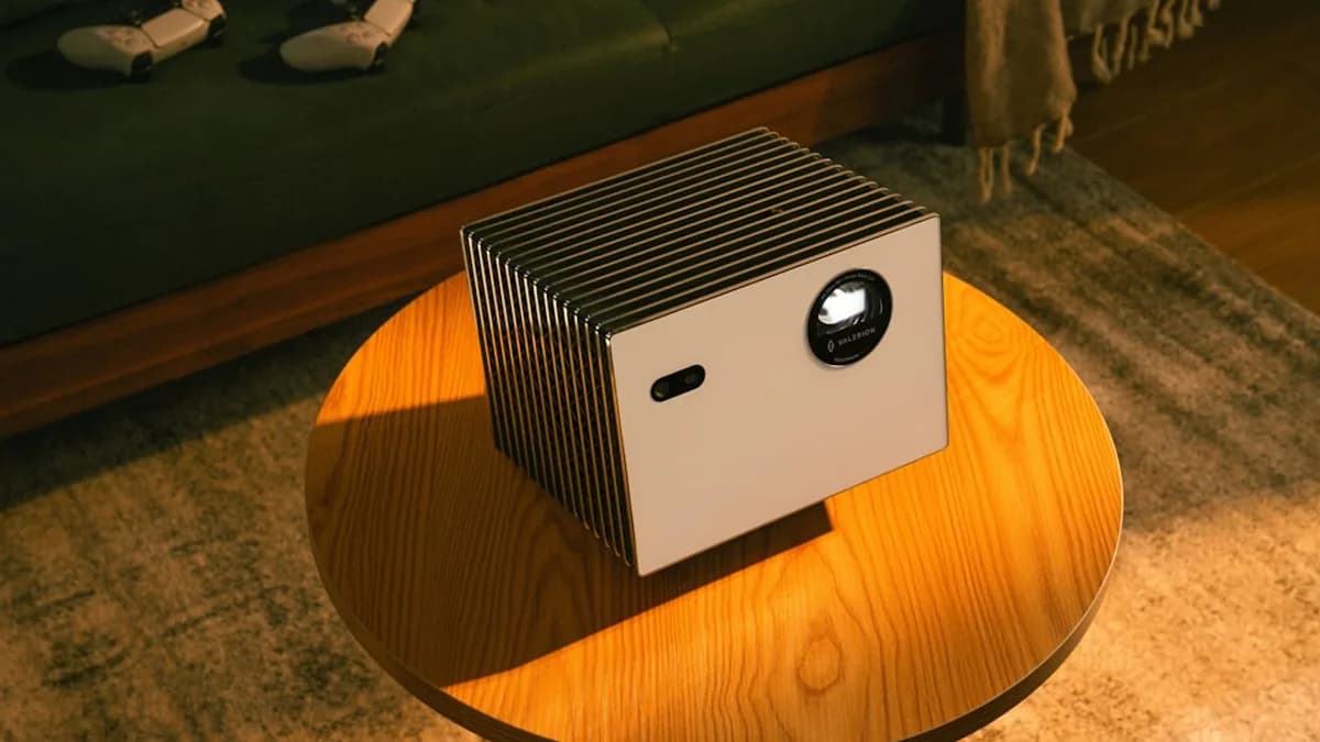 Modern projector sits on a wooden coffee table.