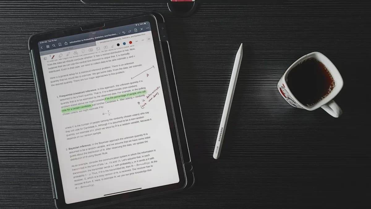 a tablet computer sitting on top of a desk next to a cup of coffee