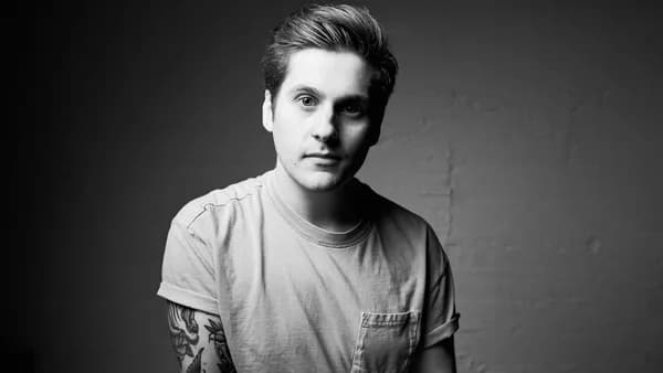 a black and white photo of a man with tattoos