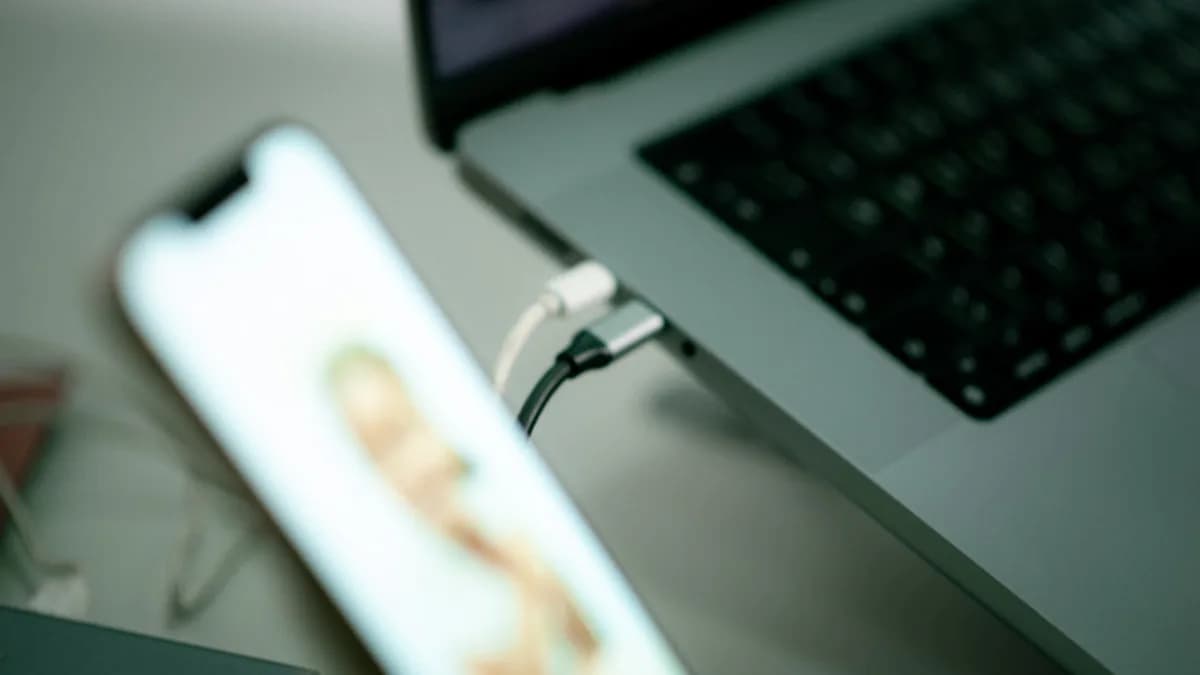 a close up of a cell phone near a laptop