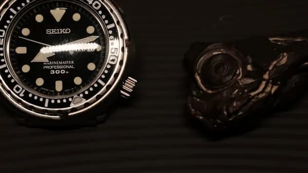 a watch sitting on top of a table next to a knife