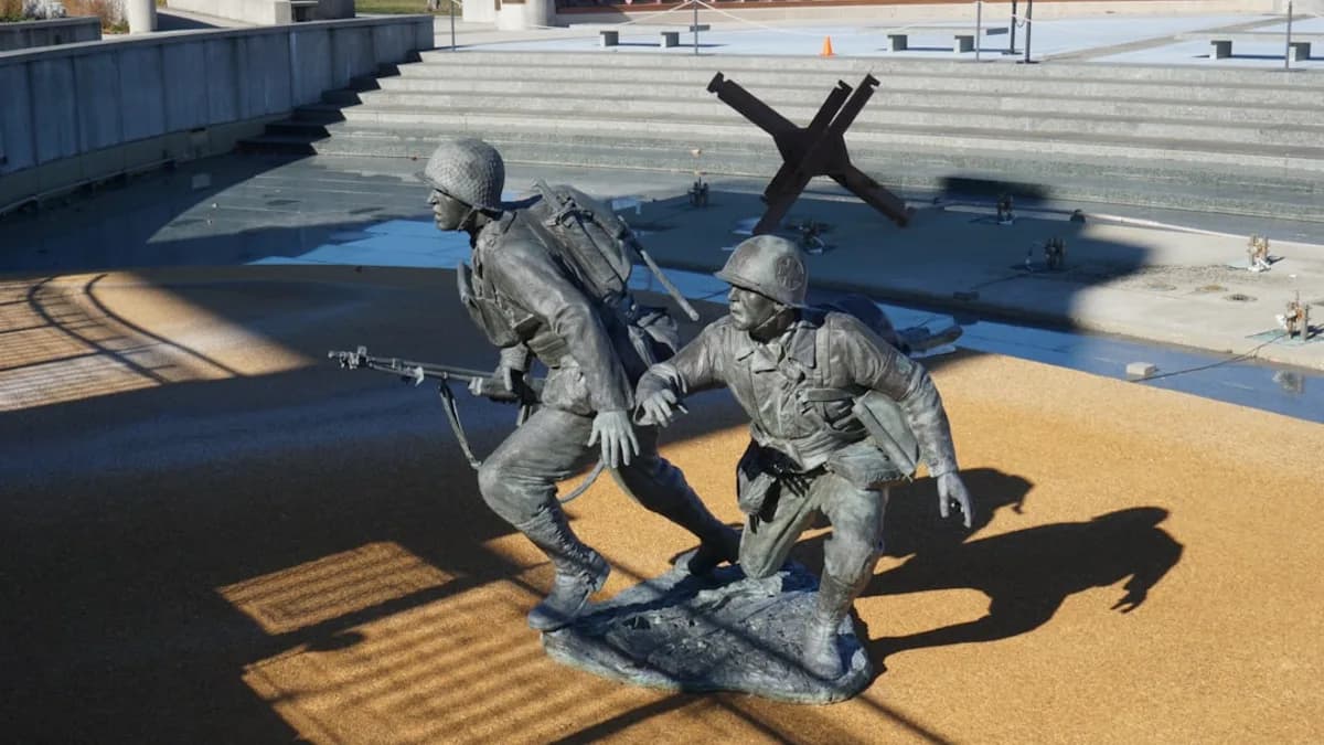 man in black and gray suit holding rifle statue