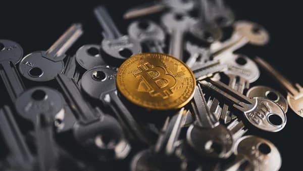 a pile of keys with a bitcoin on top of them