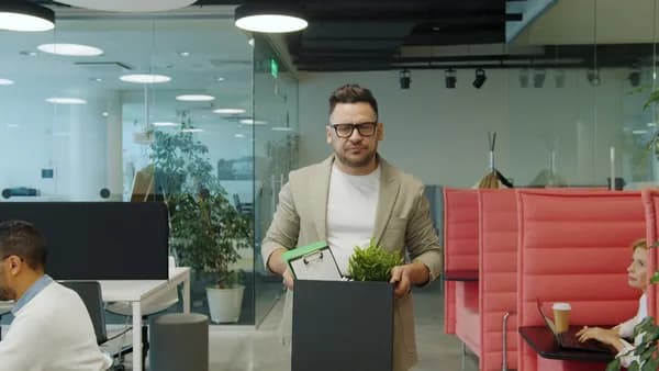 Man carrying box of belongings in office