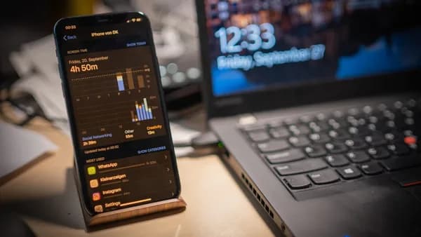 black smartphone beside laptop