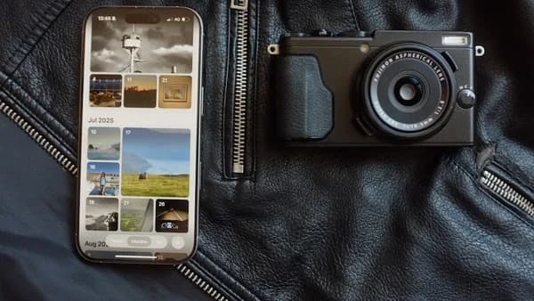 Smartphone and camera on black leather