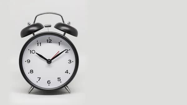 a black and white alarm clock on a white background