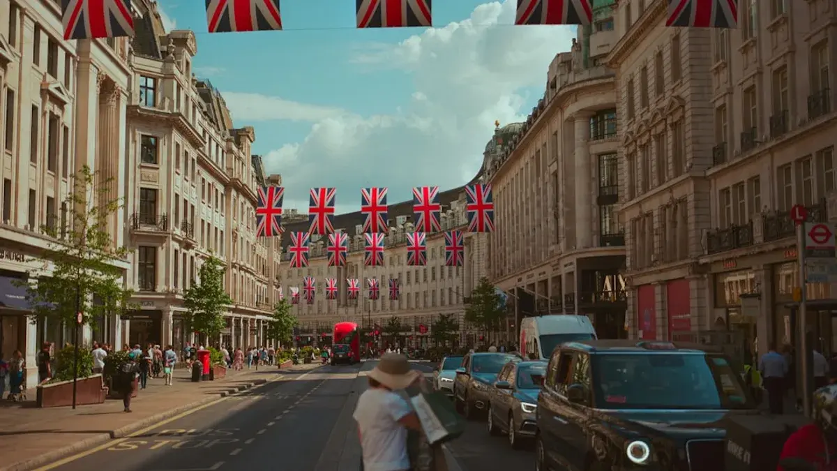 Union jack flags adorn a london street with people.