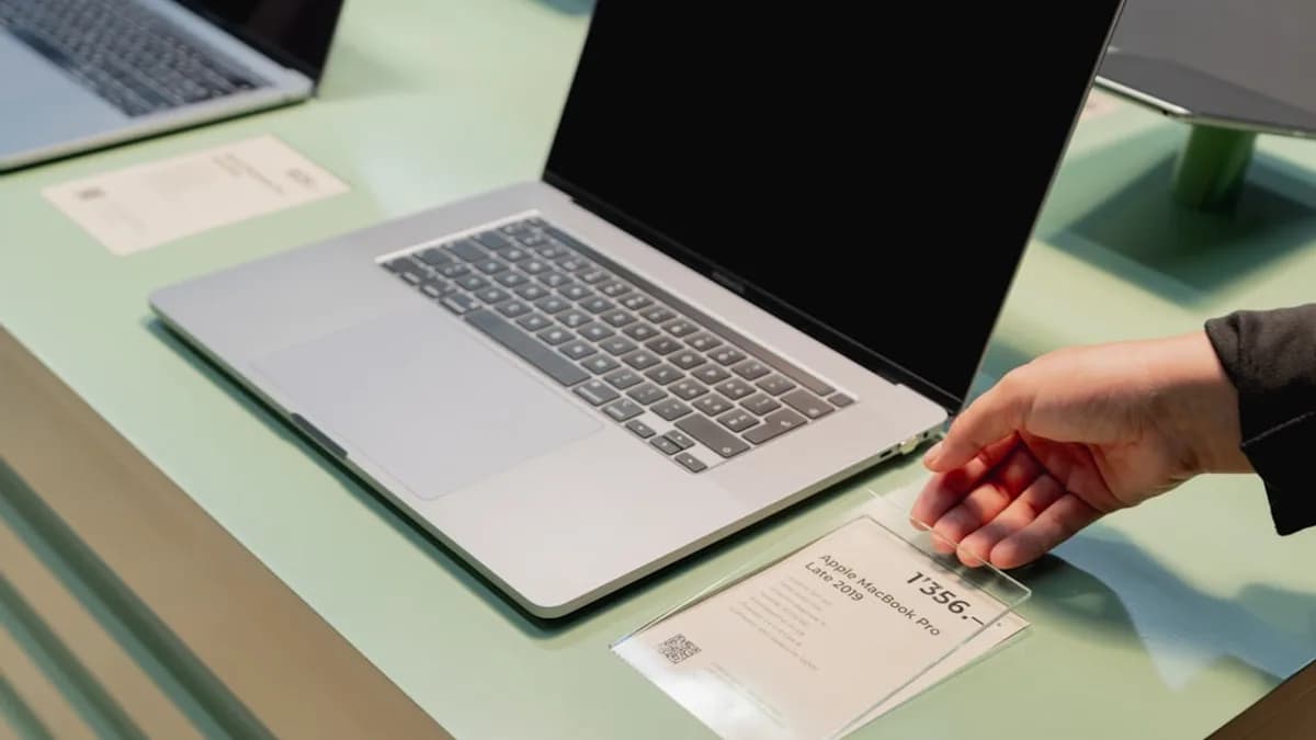 a person's hand on top of a laptop computer