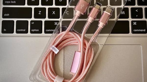a couple of pink cables sitting on top of a laptop